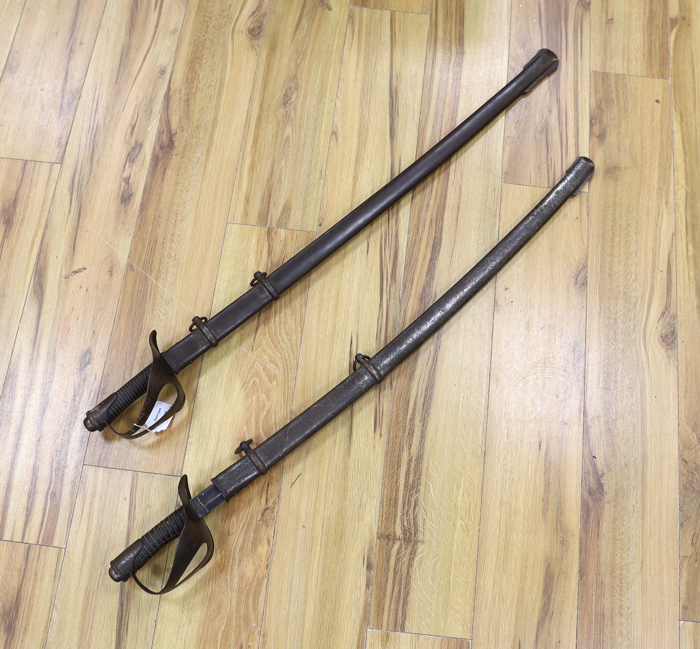 A pair of late 19th century German swords, one in its scabbard, together with another unrelated scabbard, made for the international arms trade, probably in Solingen, blade 89cm. Condition - fair, scabbards are 87cm and